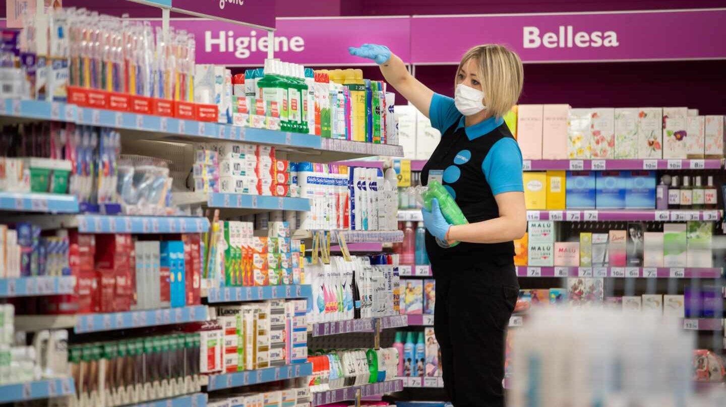Empleada de un supermercado cubierta con una mascarilla.
