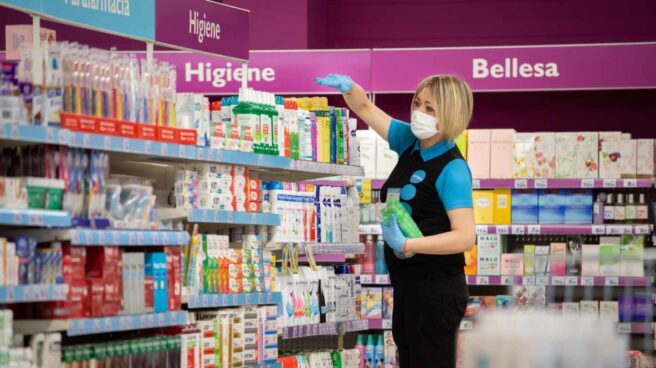 Empleada de un supermercado cubierta con una mascarilla.