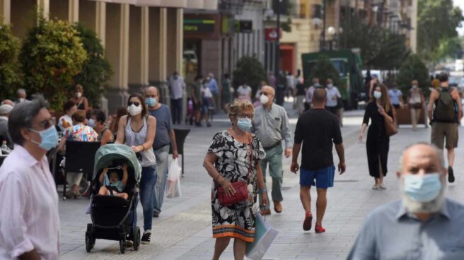 Varias personas con mascarilla caminan por las calles de Huesca.