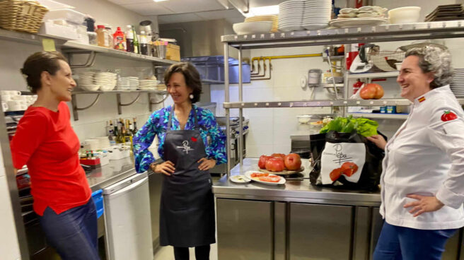 Ana Botín, con delantal negro, junto a Mila Nieto y Pepa Muñoz -con chaquetilla blanca-, las dos socias de El Qüenco de Pepa.