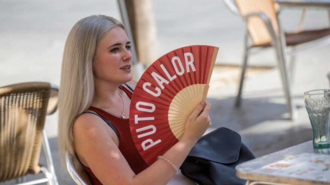 Una mujer se abanica por las altas temperaturas.