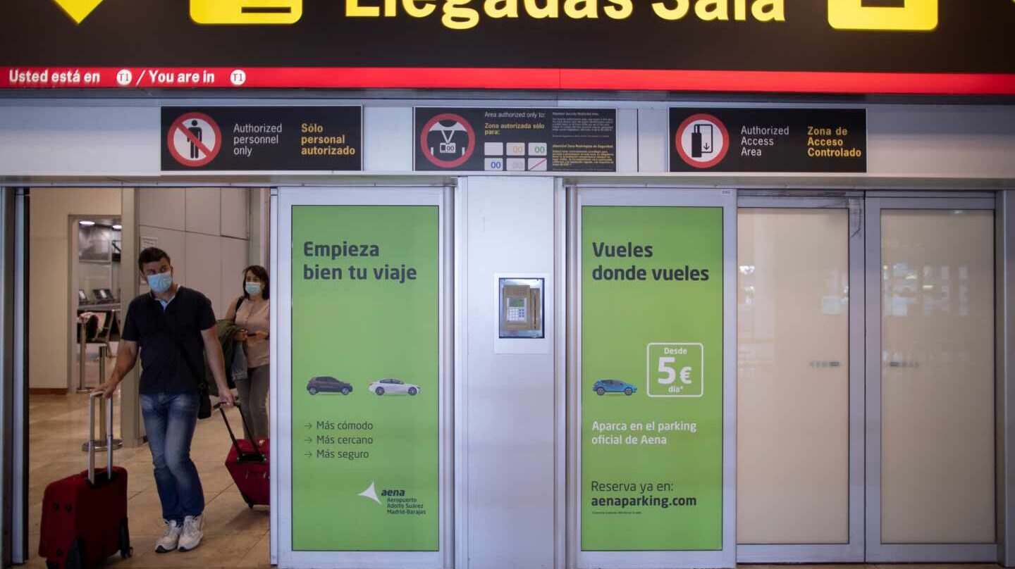 Pasajeros con mascarillas llegan al aeropuerto de Madrid-Barajas.