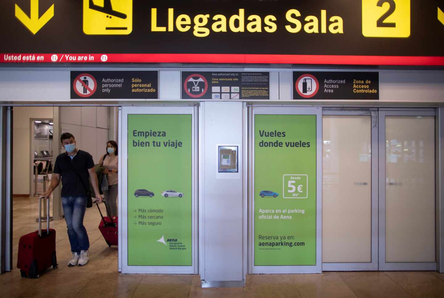 Pasajeros con mascarillas llegan al aeropuerto de Madrid-Barajas.