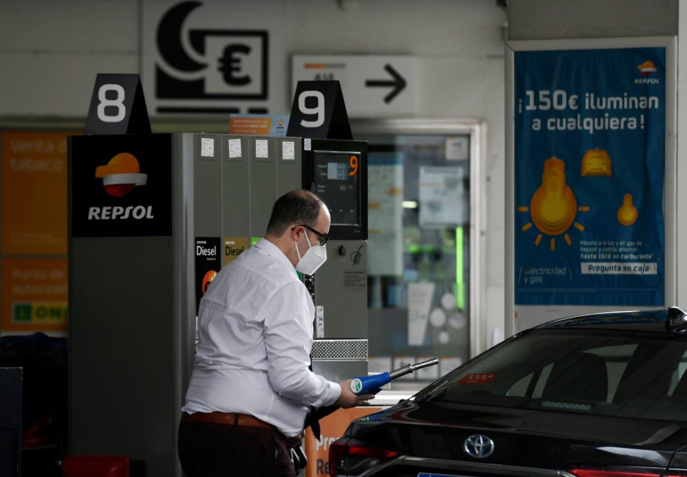 Un conductor reposta con mascarilla en una gasolinera.