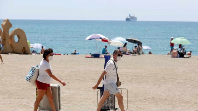 Dos bañistas con mascarillas en la playa de Málaga.