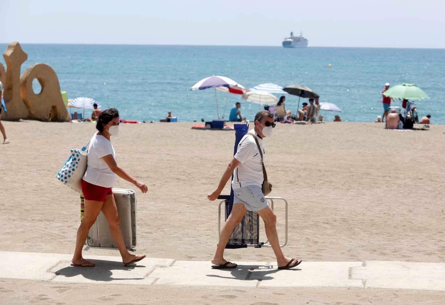 Dos bañistas con mascarillas en la playa de Málaga.