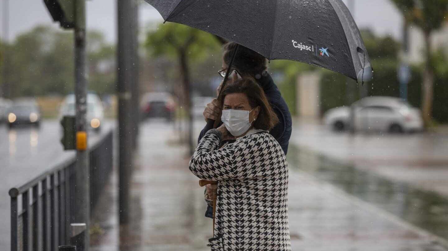 Dos personas sujetan un paraguas durante una tormenta.