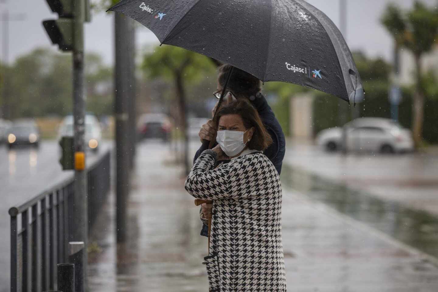 Dos personas sujetan un paraguas durante una tormenta.
