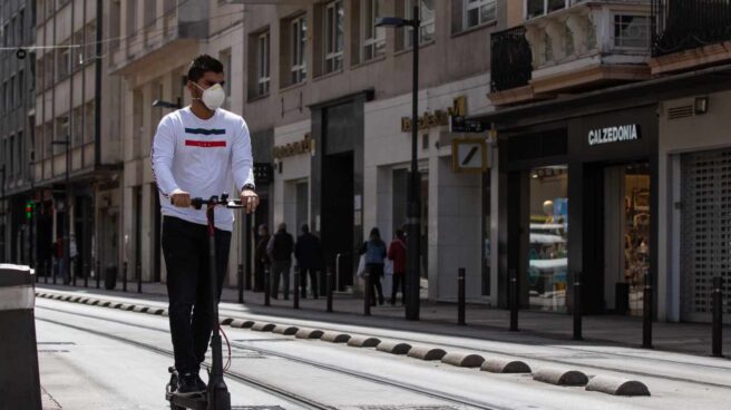 La DGT multará con 200 euros por circular con patinetes y bicicletas por zona peatonal Un hombre monta en patinete.