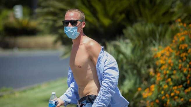 Un hombre paseando por la calle con la camisa desabrochada por el intenso calor.