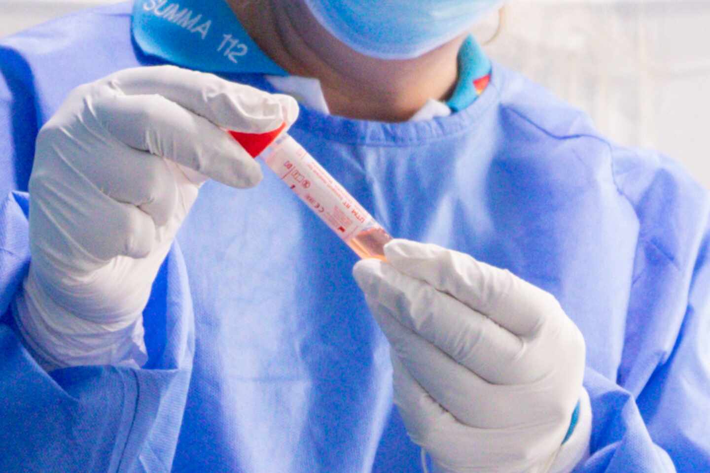 Un trabajador sanitario protegido sostiene una de las probetas utilizadas para la realización de tests PCR.