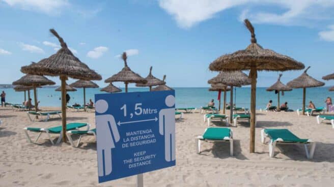 Cartel informativo sobre la distancia de seguridad en una playa de Mallorca.