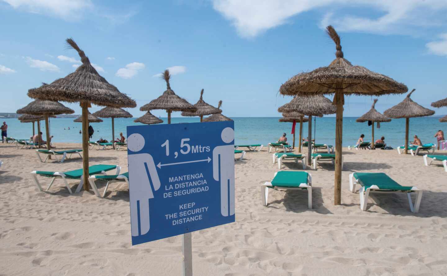 Cartel informativo sobre la distancia de seguridad en una playa de Mallorca.