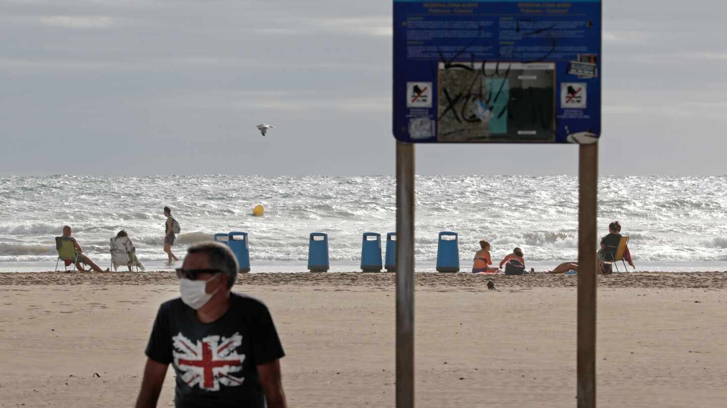 Bañista con mascarilla en la playa de la Malvarrosa de Valencia.