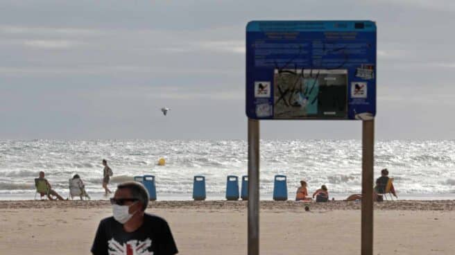 Bañista con mascarilla en la playa de la Malvarrosa de Valencia.