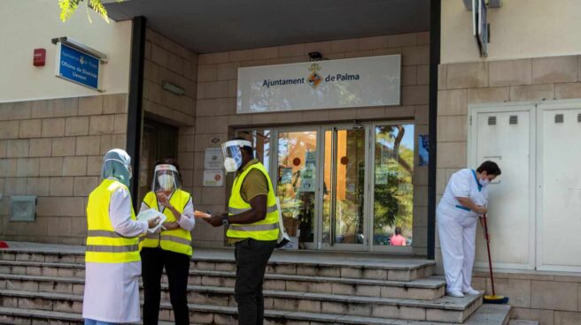 Trabajadores de Sanidad informan a los vecinos de Son Gotleu de las nuevas medidas en Palma de Mallorca.