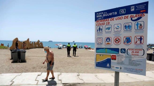 Un bañista con mascarilla en la playa de Málaga.