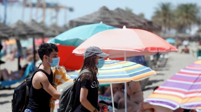 Dos bañistas con mascarilla en una playa de Almería.