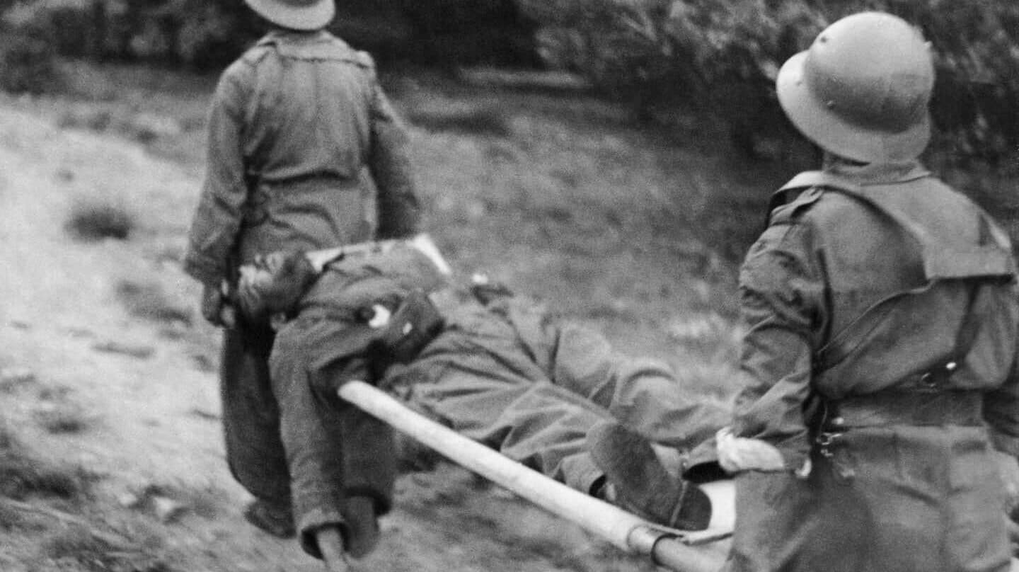 Dos hombres portan un herido foto de Gerda Taro realizada en la Guerra Civil