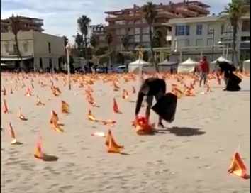 Militantes del Frente Obrero arrancan las banderas por las víctimas del Covid de la playa de Valencia