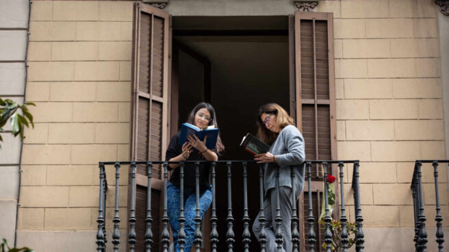 Dos jóvenes leen en el balcón de su casa