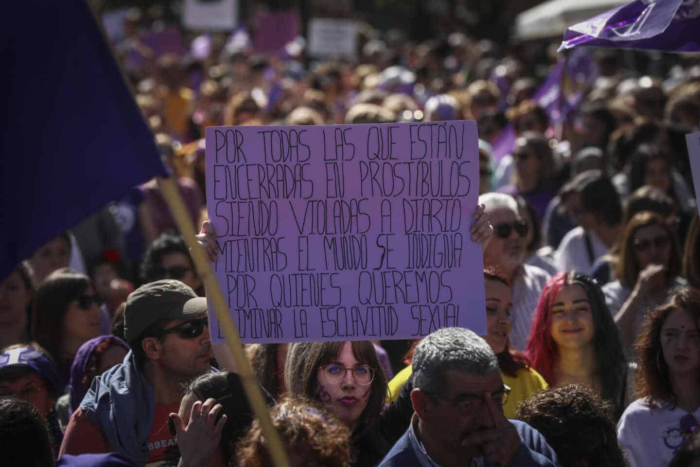 Una mujer sostiene su pancarta contra de la prostitución durante el 8-M en Sevilla.