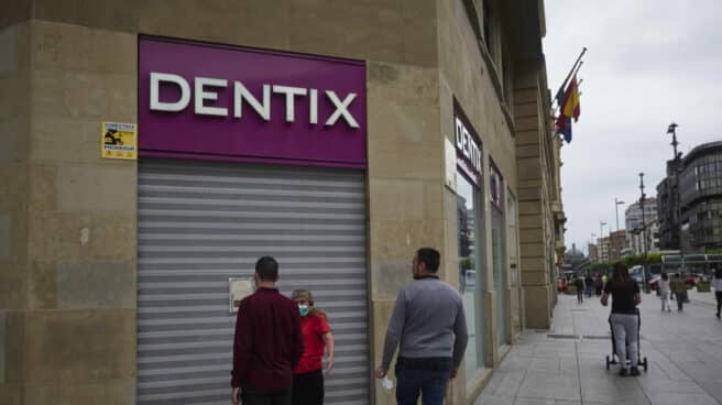 Una mujer se apoya en la puerta de una clínica Dentix, en una foto de archivo.