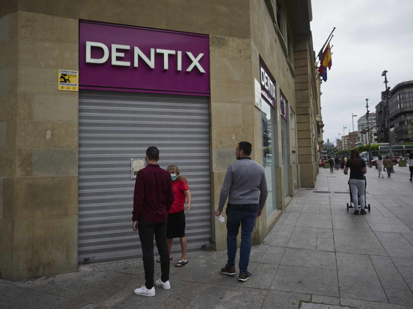 Una mujer se apoya en la puerta de una clínica Dentix, en una foto de archivo.