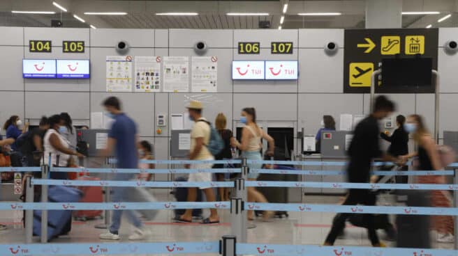 Varios pasajeros hacen cola en los mostradores de facturación de Tui en el aeropuerto de Palma de Mallorca, en una imagen de archivo.