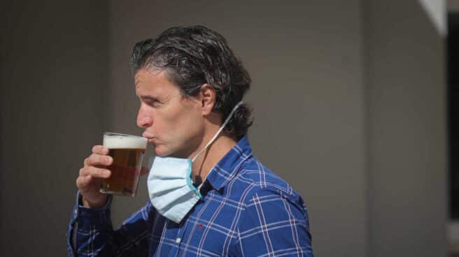 Un hombre bebe una cerveza en Sevilla.