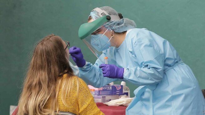 pruebas pcr bajan el precio Una sanitaria hace una prueba PCR a una joven en el País Vasco.