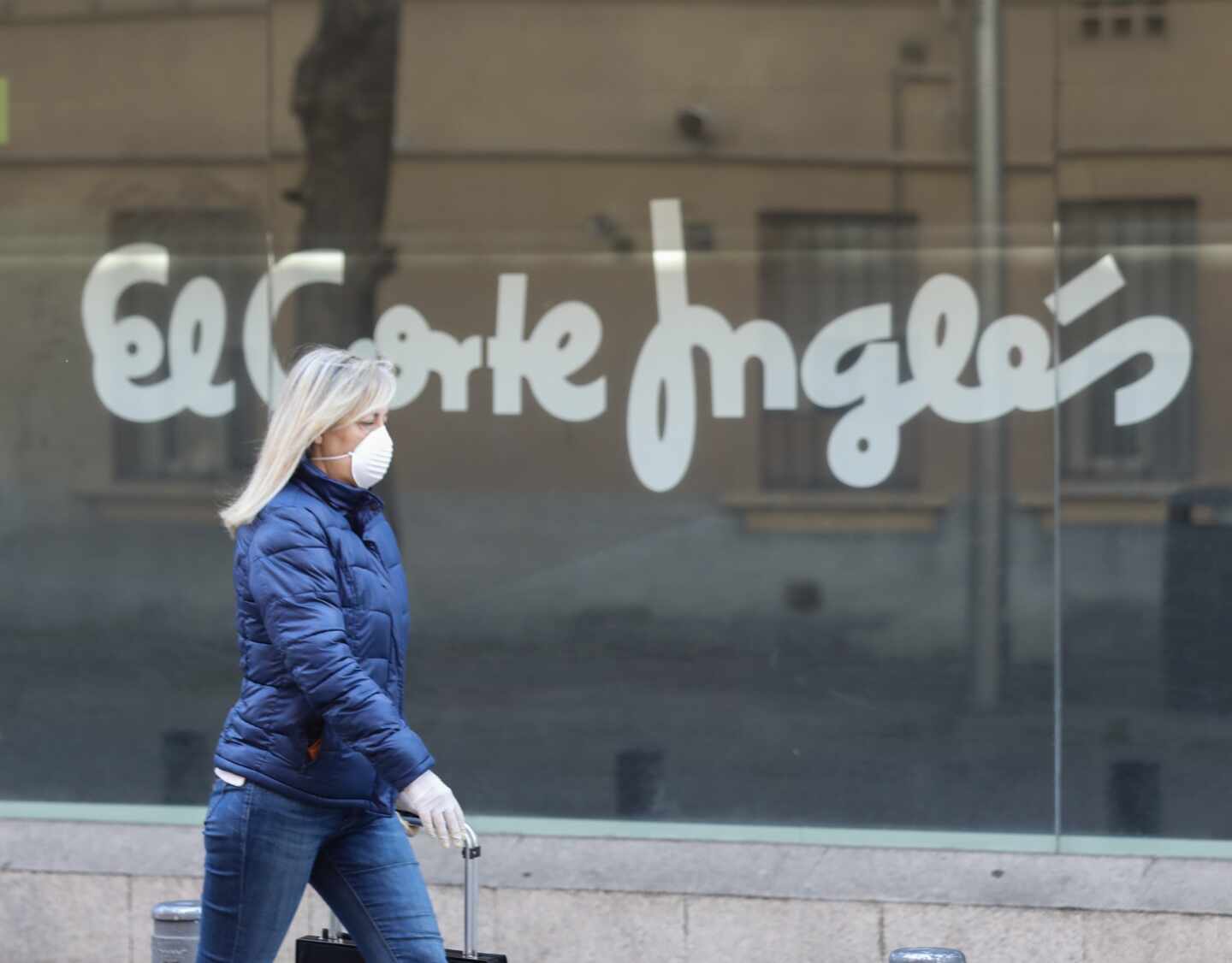 Una mujer pasa por delante de un centro de El Corte Inglés.