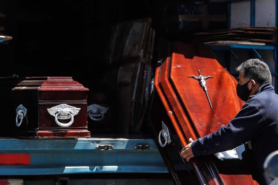 Personal de una funeraria descarga ataúdes de un camión en Buenos Aires, Argentina.