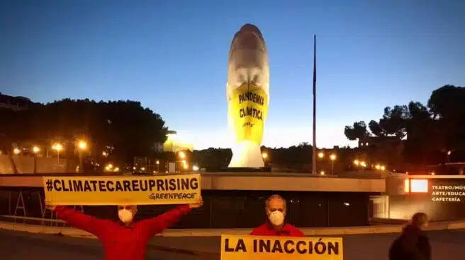 Greenpeace coloca una mascarilla gigante en una estatua de la plaza de Colón