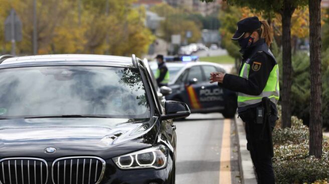 Una agente de la Policía Nacional comprueba la documentación de un conductor durante un control en Madrid. control-policia-madrid-1440x873