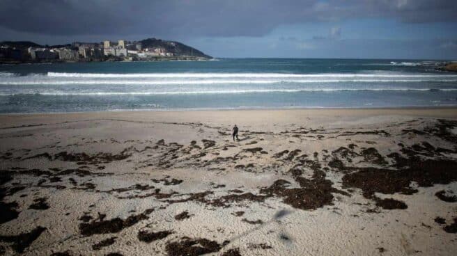 Un surfista camina por la playa del Orzán de A Coruña.