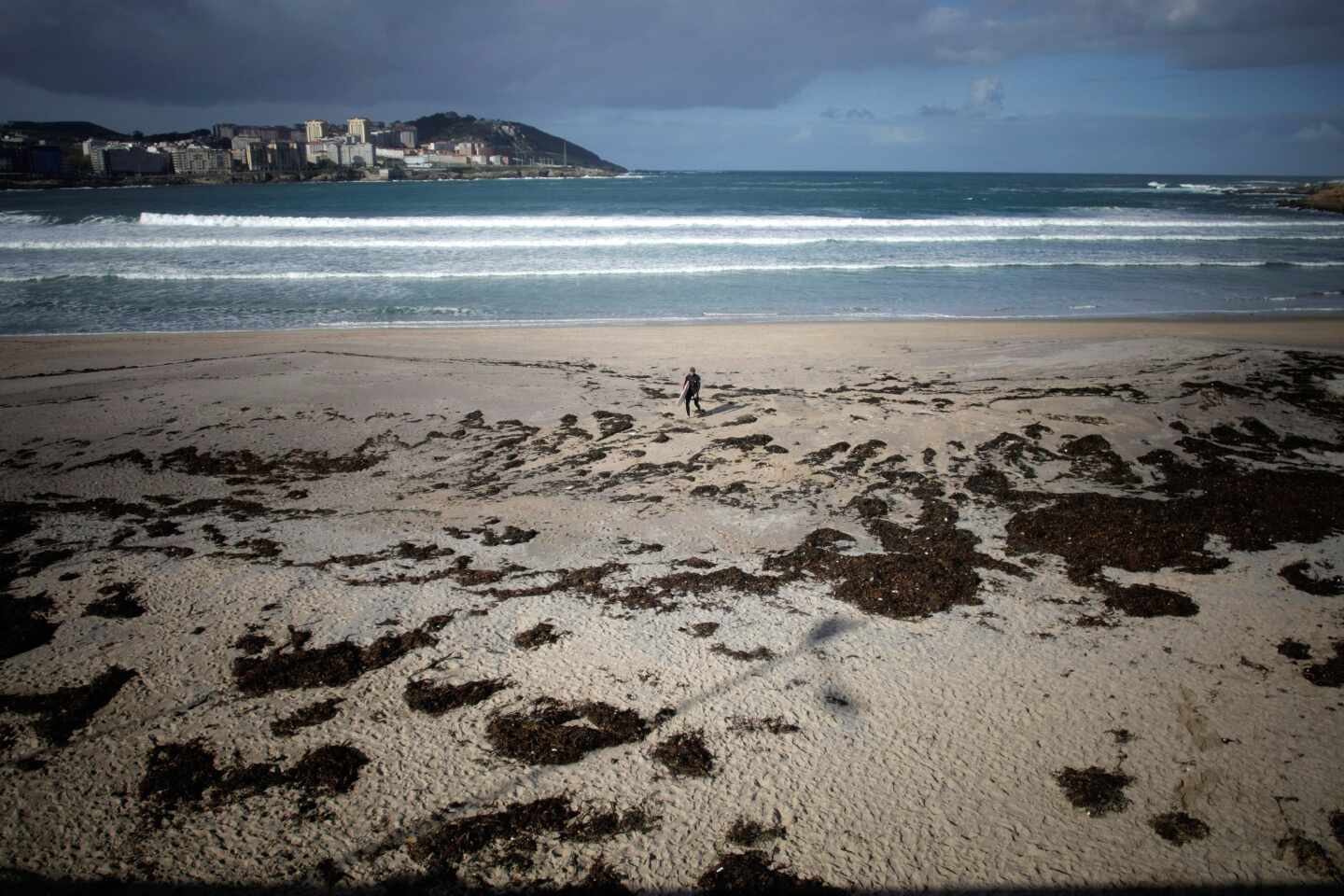 Un surfista camina por la playa del Orzán de A Coruña.