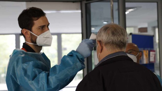 Continúan los test antígenos en zonas básicas de salud de Vicálvaro y Pozuelo Personal sanitario toma la temperatura a una persona en la entrada de un centro de mayores en Madrid.
