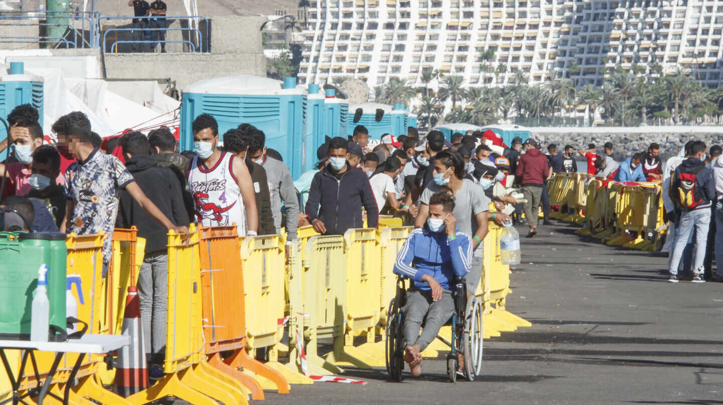 Centenares de inmigrantes hacen cola en el muelle de Arguineguín, en la localidad grancanaria de Mogán.