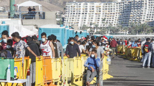 Centenares de inmigrantes hacen cola en el muelle de Arguineguín, en la localidad grancanaria de Mogán.