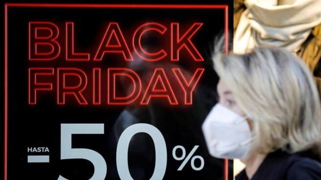 Una persona pasa ante un escaparate con promociones del "Black Friday" en Valencia.