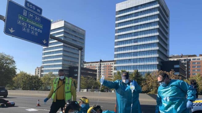 Efectivos de emergencias atienden a la víctima de la colisión en la M-30, en Madrid.