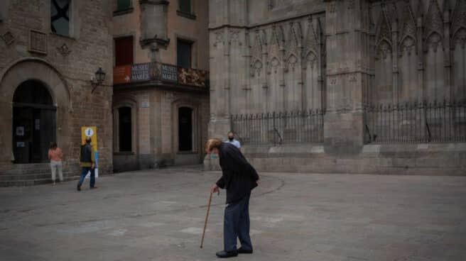 Un anciano camina por una plaza del Barrio Gótico de Barcelona.