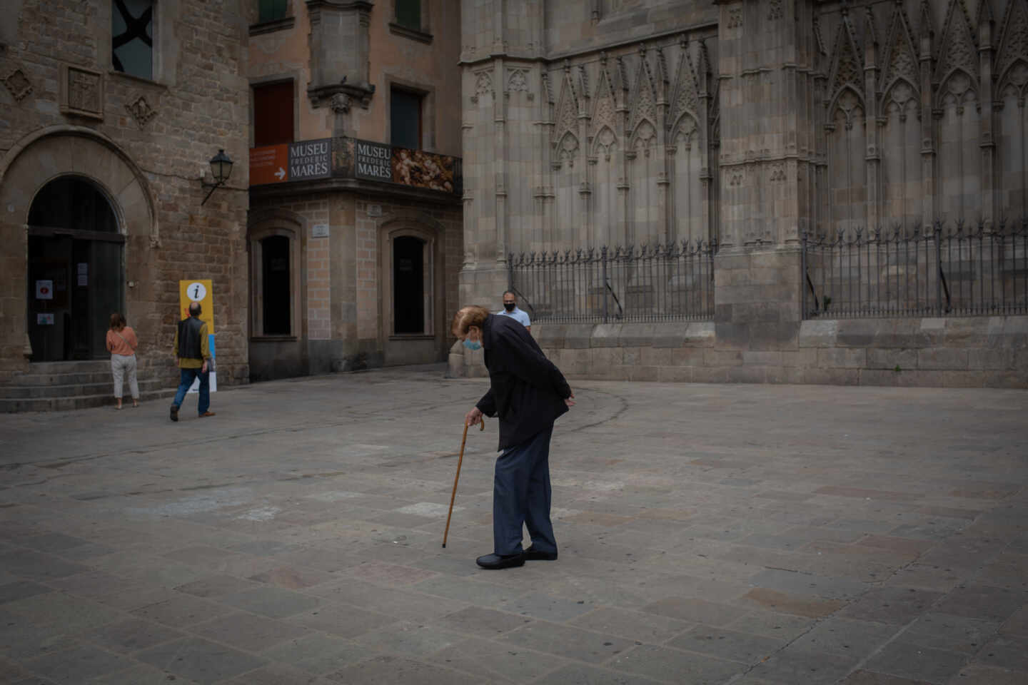 Un anciano camina por una plaza del Barrio Gótico de Barcelona.