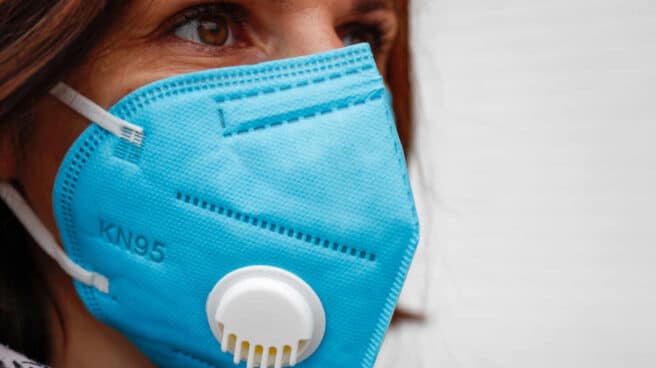 El gobierno hace obligatorio el uso de mascarilla al aire libre Mujer usando una mascarilla al aire libre