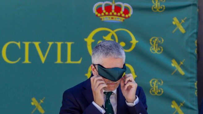 Indignación en Cádiz: la Guardia Civil ofrece una sola vacante para el campo de Gibraltar El ministro Grande-Marlaska se coloca la mascarilla en un acto oficial de la Guardia Civil.