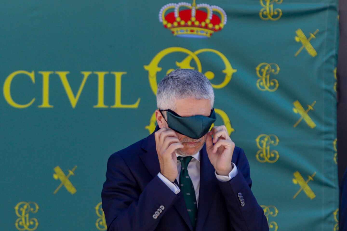 El ministro Grande-Marlaska se coloca la mascarilla en un acto oficial de la Guardia Civil.