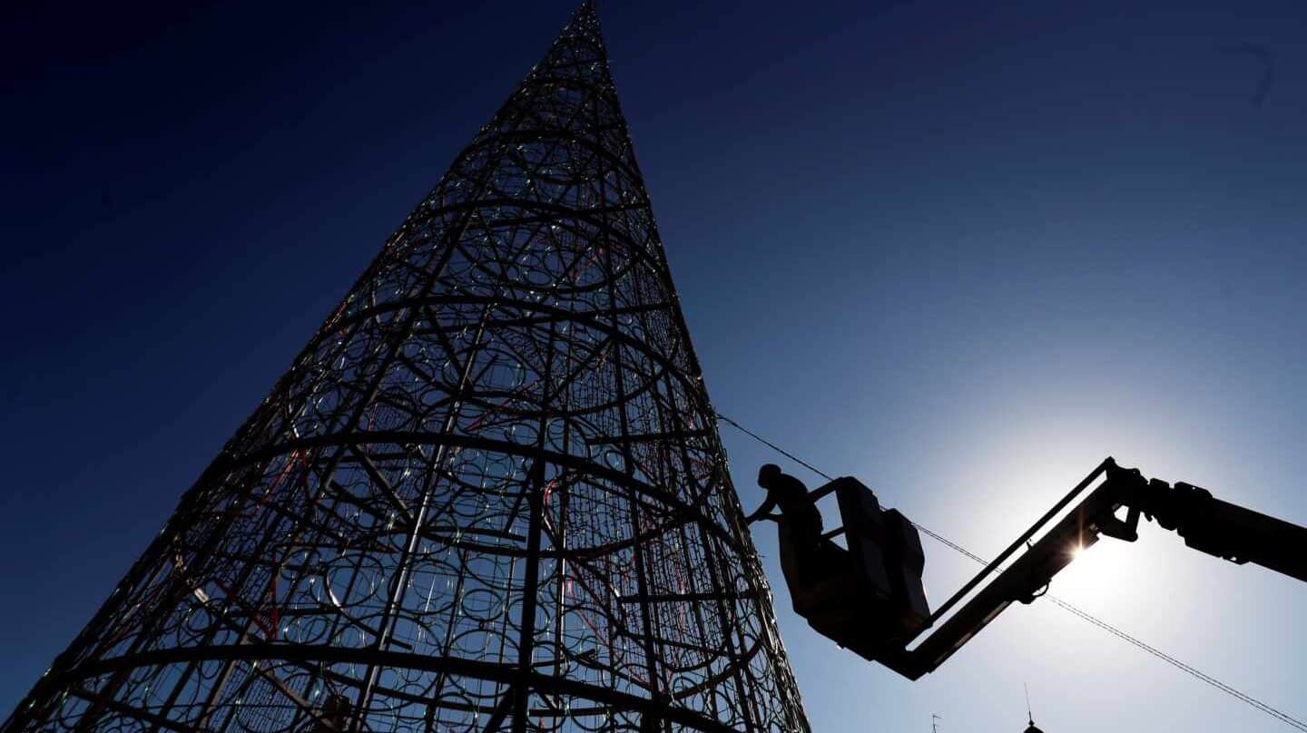 Un operario trabaja en el montaje del árbol de navidad de la plaza del Ayuntamiento de Valencia.