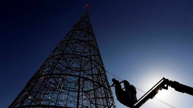Un operario trabaja en el montaje del árbol de navidad de la plaza del Ayuntamiento de Valencia.