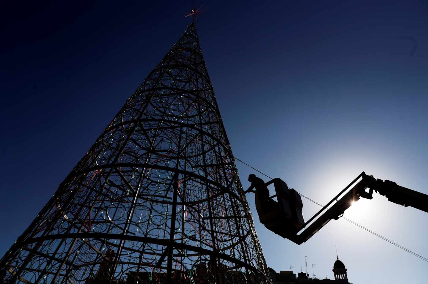 Un operario trabaja en el montaje del árbol de navidad de la plaza del Ayuntamiento de Valencia.